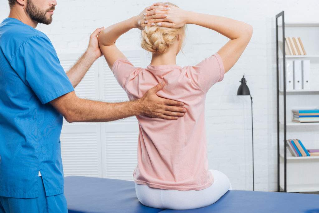 partial view of physiotherapist doing massage to woman on massage table in hospital