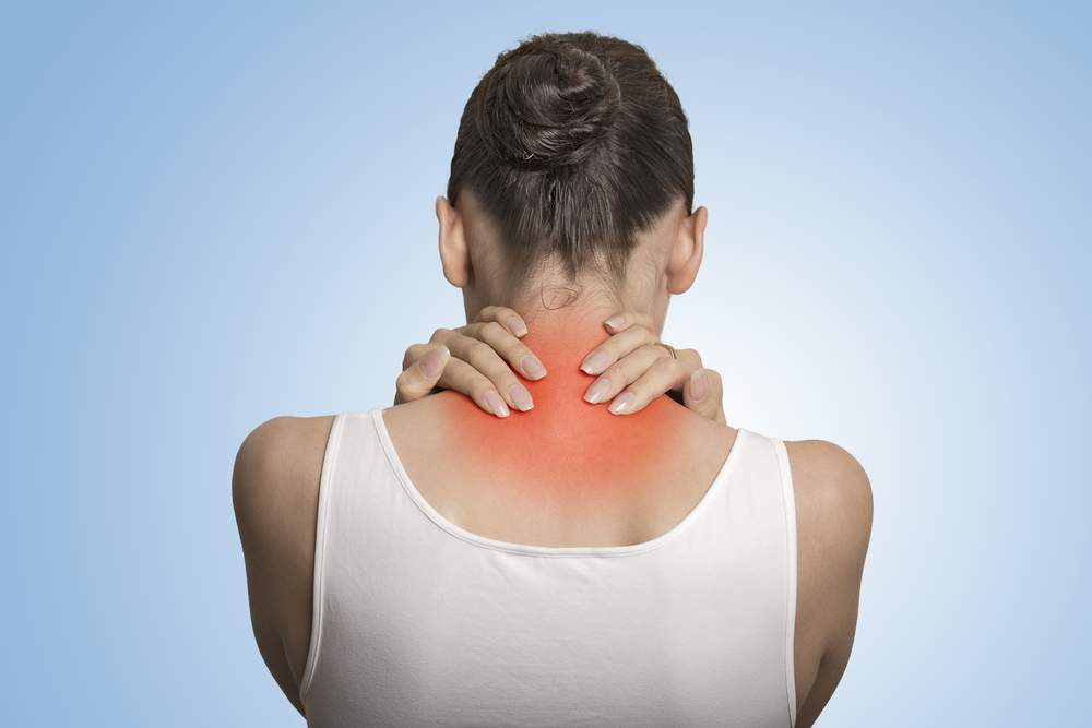 Woman feeling back of neck due to fibromyalgia.