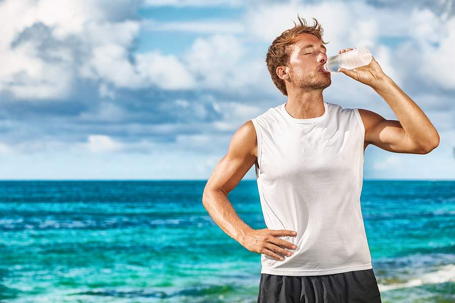 Man drinking water at the beach.