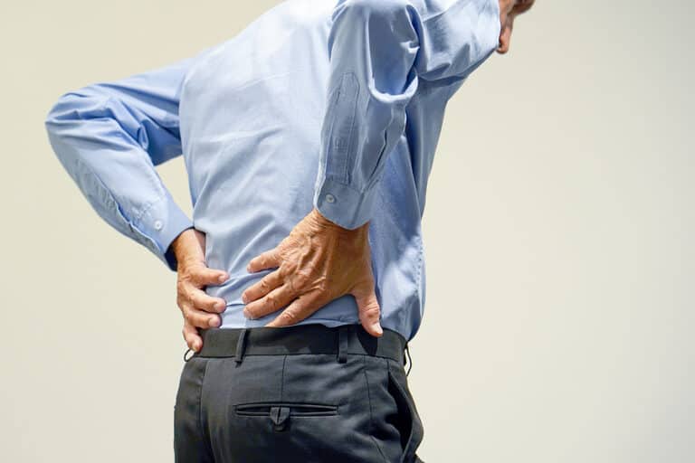 Man feeling lower back for pain.